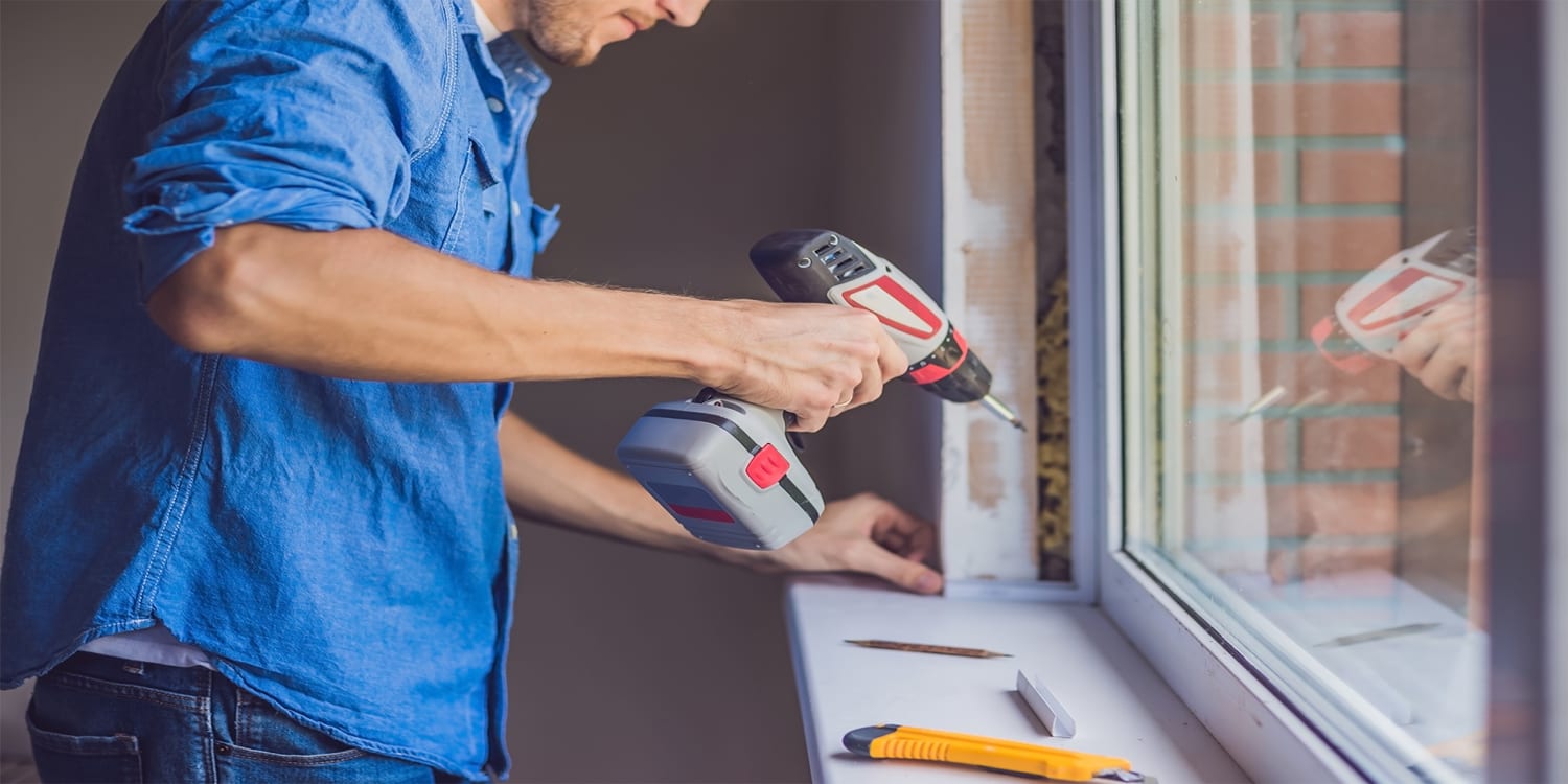 Home repairs, man installing new window